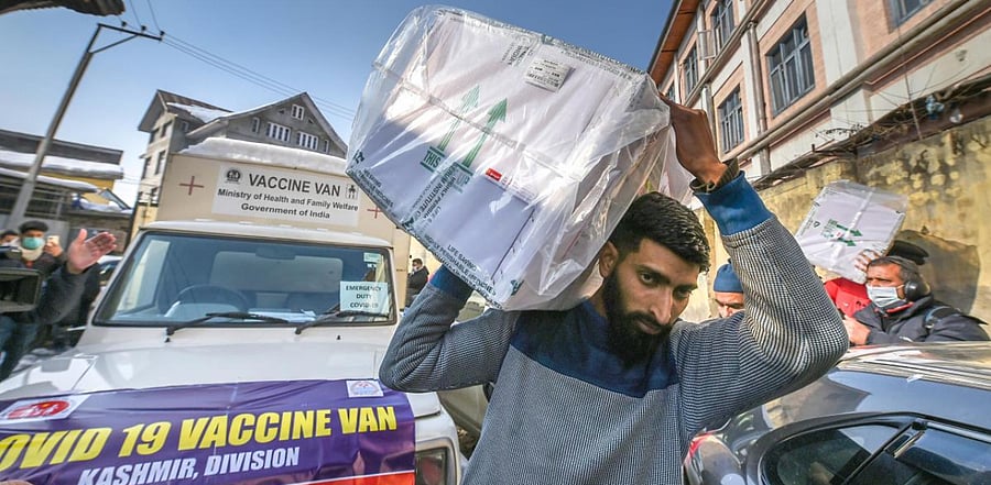 Medical department workers unload boxes of Covid-19 vaccines from a vehicle at cold storage of a hospital, in Srinagar. Credit: PTI Photo