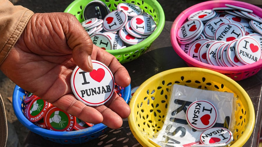 A farmer purchases badges during the ongoing agitation over the farm reform laws, at Singhu border in New Delhi. Credit: PTI Photo