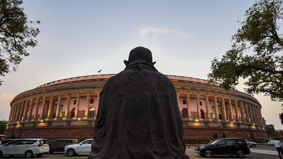 Mahatma Gandhi's statue in the backdrop of Parliament House. Credit: PTI Photo