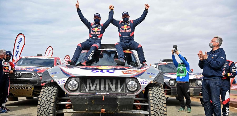Stephane Peterhansel (R) celebrates with teammates following his victory in the Dakar Rally in Saudi Arabia. Credit: AFP Photo