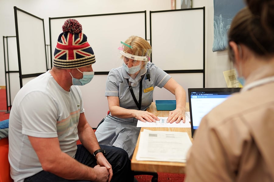 Key Worker Mark Reid (L) from North Shields is briefed before he receives the Pfizer-BioNTech Covid-19 vaccine at the Life Science Centre at the International Centre for Life in Newcastle upon Tyne, northeast England, on January 9, 2021 one of the seven mass vaccination centres, which will open to the public next week as Britain continues with their Covid-19 vaccination programme. - The Centre For Life in Newcastle vaccinated key workers this weekend. It will be one of seven mass vaccination hubs opening around the country. UK health officials and ministers have described the vaccination roll-out as a head-to-head race against the virus and the vaccination programme as the best hope of a return to normality. Representative image/Credit: AFP Photo