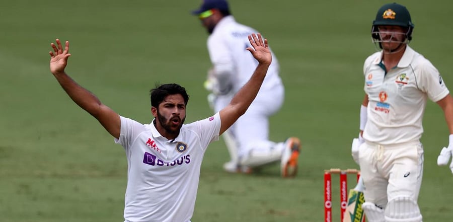 India's Shardul Thakur(L) reacts after bowling to Australia's batsman David Warner on day four of the fourth cricket Test match between Australia and India at The Gabba in Brisbane on January 18, 2021. Credit: AFP Photo