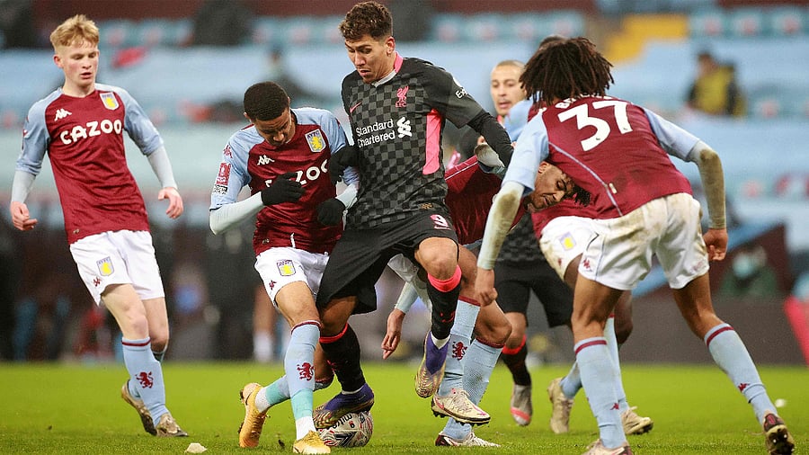 Liverpool's Brazilian midfielder Roberto Firmino (C) vies with Aston Villa's English defender Mungo Bridge. Credit: AFP Photo