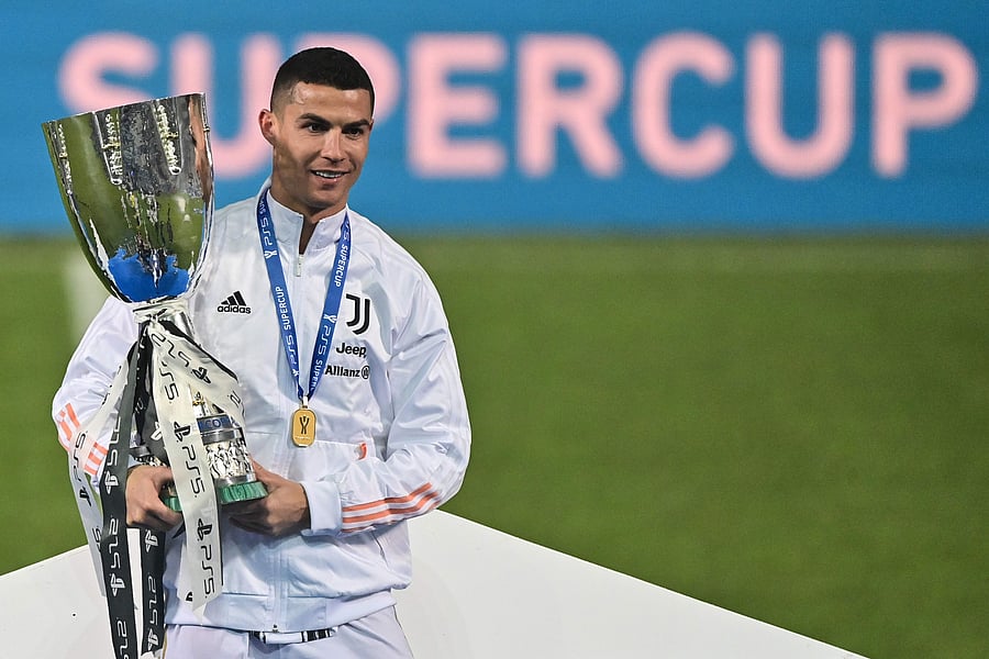 Juventus' Portuguese forward Cristiano Ronaldo poses with the winners' trophy after Juventus won the Italian Super Cup (Supercoppa italiana) football match against Napoli on January 20, 2021 at the Mapei stadium - Citta del Tricolore in Reggio Emilia. - The 33rd edition of the Italian football Super Cup is played between Juventus, the winners of the 2019–20 Serie A championship, and Napoli, the winners of the 2019–20 Italian Cup (Coppa Italia). Credit: AFP Photo