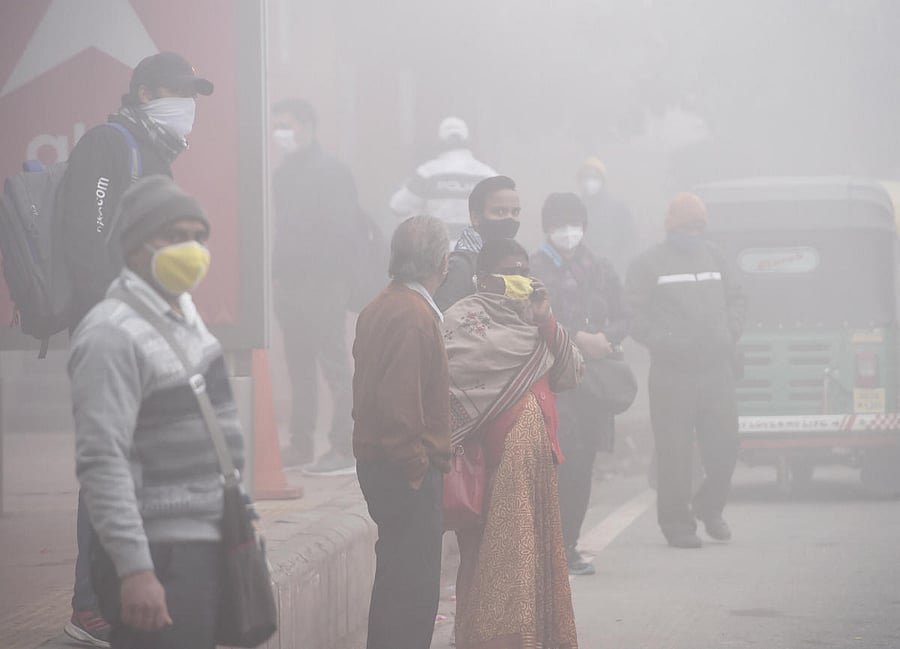  People wait for transport amid low visibility due to dense fog on a winter morning, in New Delhi. Credit: PTI. 