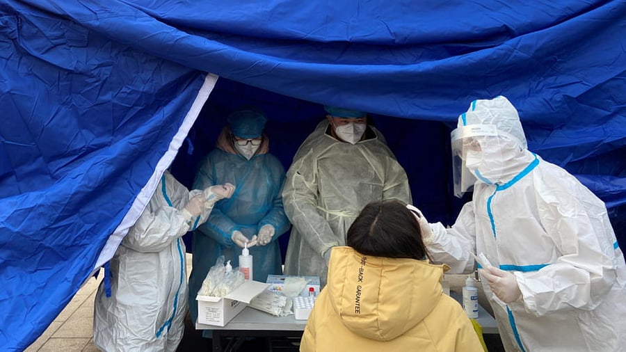 A medical worker in a protective suit collects a swab from a woman for nucleic acid testing at a makeshift testing site following the coronavirus disease (COVID-19) outbreak in Beijing, China January 22, 2021. Credit: Reuters Photo