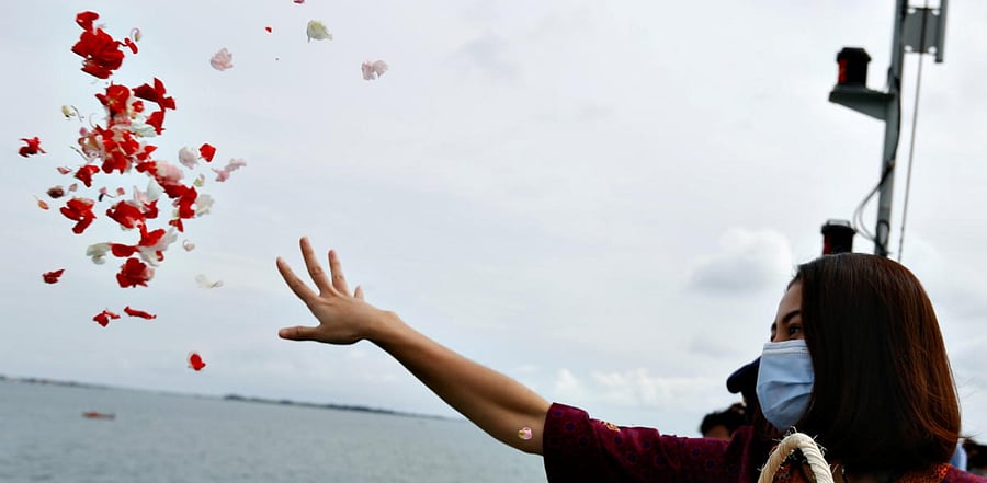A colleague of the crew of Sriwijaya Air flight SJ 182, which crashed into the sea, throws flowers and petals from the deck of Indonesia's Naval ship KRI Semarang as they visit the site of the crash to pay their tribute, at the sea off the Jakarta coast, Indonesia. Credit: Reuters Photo