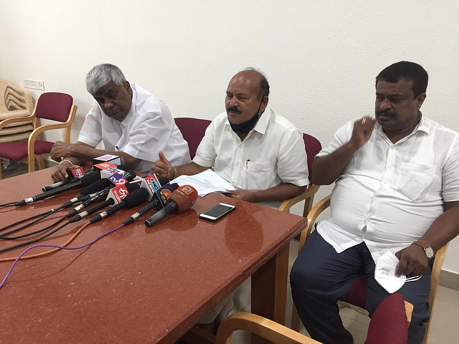 JD(S) state unit president H K Kumaraswamy addresses media in Hassan on Saturday. MLA H D Revanna and C N Balakrishna are seen. Credit: DH PHOTO