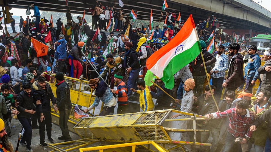  Farmers attempt to break police barricade as they try to march towards Delhi near Nangloi during the 'Kisan Gantantra Parade', amid the 72nd Republic Day celebrations, in New Delhi, Tuesday, Jan. 26, 2021. Credit: PTI Photo