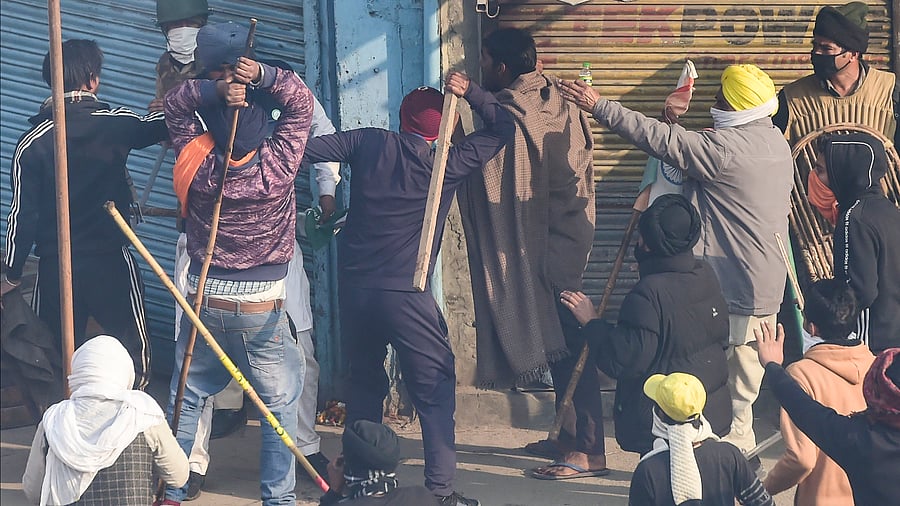 Farmers charge a security person during clashes after their tractor rally turned violent, in New Delhi. Credit: PTI Photo