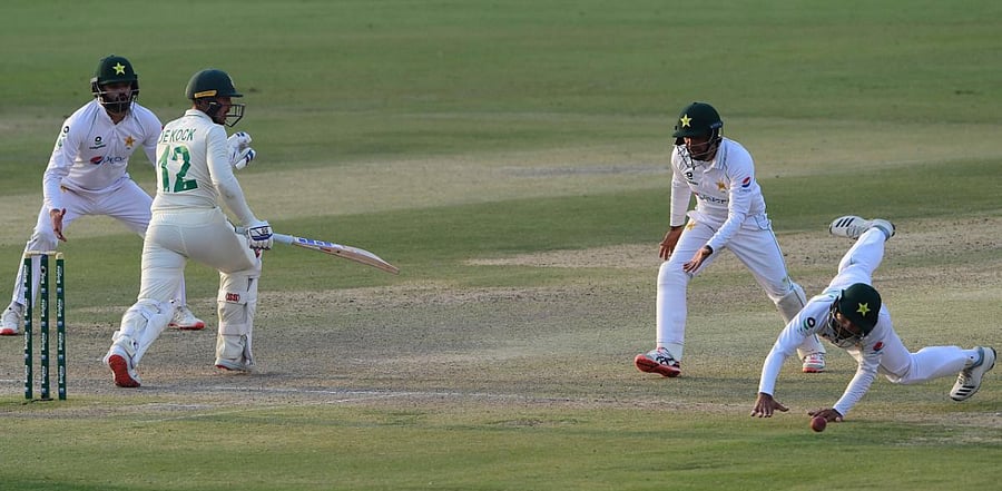 South Africa's captain Quinton de Kock (2L) plays a shot as Pakistan's Imran Butt (R) tries to filed the ball during the third day of the first cricket Test match between Pakistan and South Africa. Credit: AFP Photo