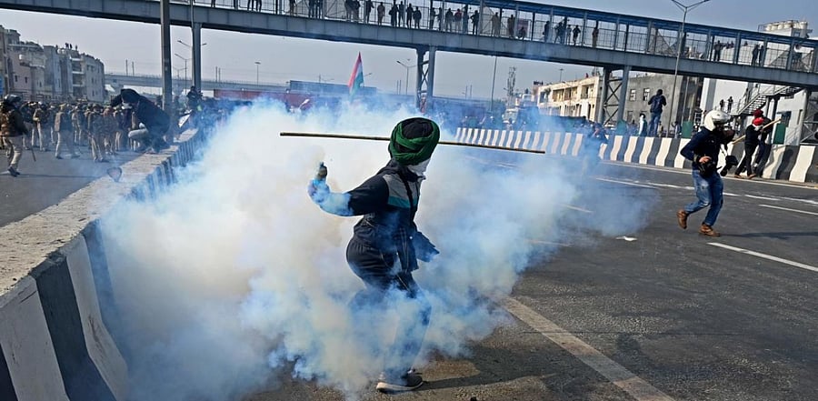 A farmer throws back a tear gas shell towards police during a tractor rally as farmers continue to protest against the central government's recent agricultural reforms in New Delhi on January 26, 2021. Credit: AFP Photo