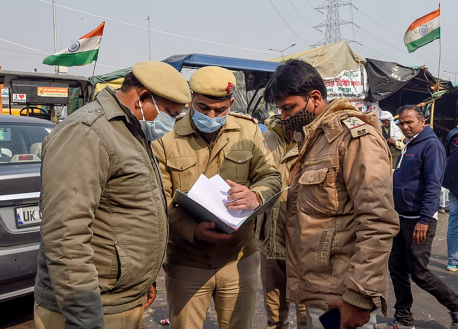 Police personnel arrive at Ghazipur border to hang notices for farmer leaders after the FIRs registered against them in connection with Republic Day violence, during the ongoing protest against the new farm laws, in New Delhi, Thursday, Jan 28, 2021. (PTI Photo/Kamal Singh)
