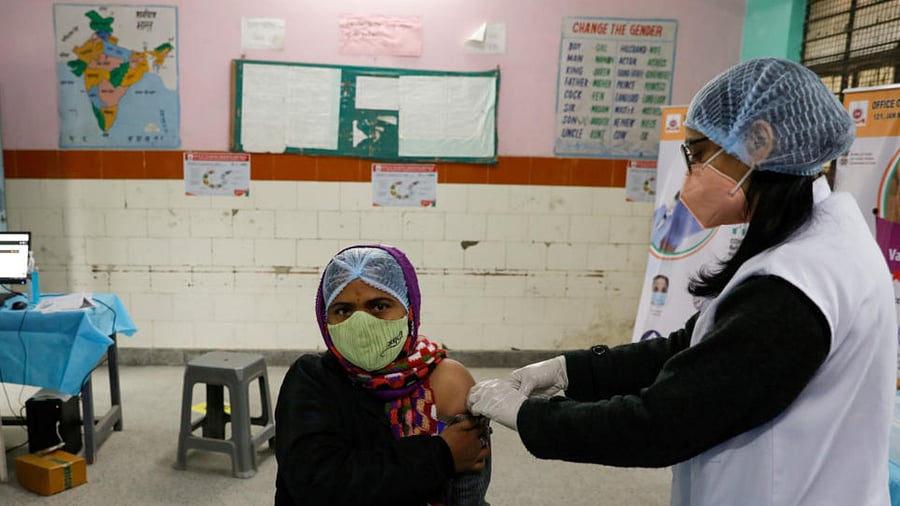 A health worker and a volunteer take part in a nationwide trial run of coronavirus disease (COVID-19) vaccine delivery systems, inside a school, which has been converted into a temporary vaccination centre, in New Delhi, India, January 8, 2021. Credit: Reuters File Photo
