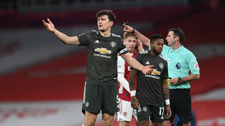 Manchester United's Harry Maguire reacts as Arsenal's Alexandre Lacazette is on the floor. Credit: Reuters Photo