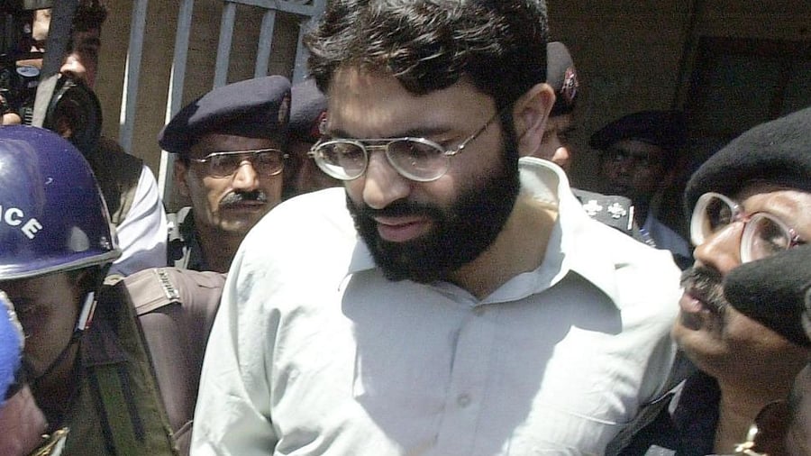 In this file taken on March 29, 2002, police escort British-born Ahmed Omar Saeed Sheikh out of a court in Karachi. Credit: AFP Photo