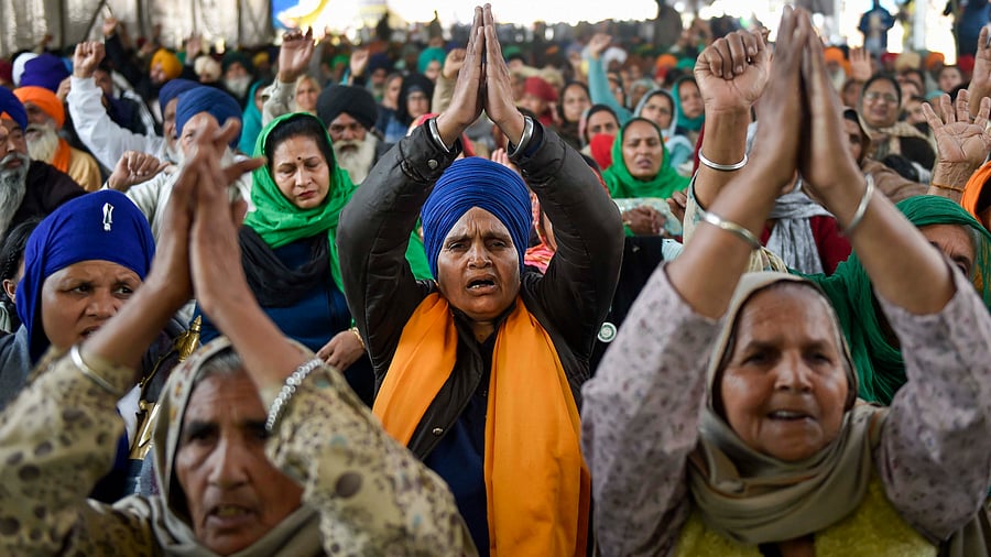Farmers raise slogans during their ongoing protest against the new farm laws at Singhu border, in New Delhi. Credit: PTI Photo