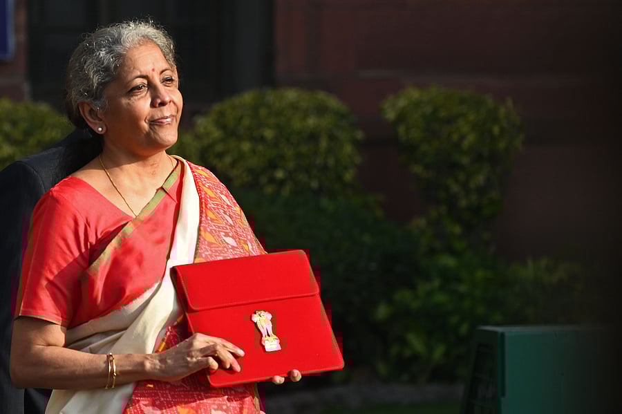 Union Finance Minister Nirmala Sitharaman poses for pictures as she leaves the Finance Ministry to present the annual budget in parliament in New Delhi on February 1, 2021. Credit: AFP Photo