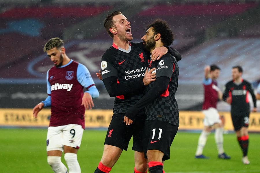 Liverpool's Egyptian midfielder Mohamed Salah celebrates scoring his team's second goal with Liverpool's English midfielder Jordan Henderson during the English Premier League football match between West Ham United and Liverpool at The London Stadium, in east London. Credit: AFP. 