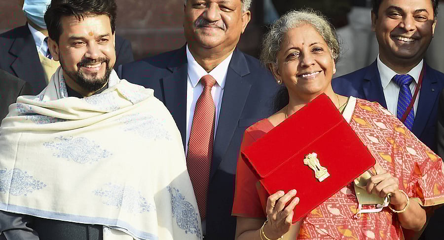 Finance Minister Nirmala Sitharaman holds a folder case containing the Union Budget 2021-22 as she poses for a group photograph with MoS Finance Anurag Thakur and other members of finance ministry, at North Block in New Delhi, Monday, Feb. 1, 2021. Credit: PTI Photo