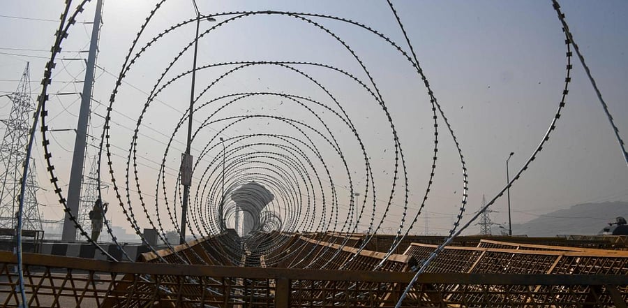 Barbed wires are seen on police barricades along a blocked highway as farmers continue their protest against the Central Government's recent agricultural reforms at Delhi-Uttar Pradesh state border. Credit: AFP Photo