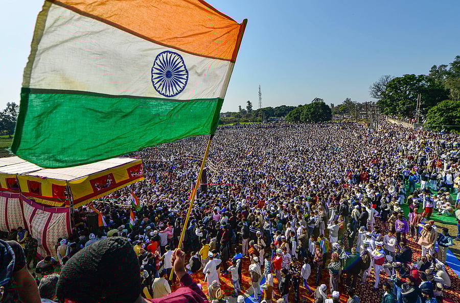 A farmer waves the Indian flag during the 'Kisan Mahapanchayat', in Shamli district of Uttar Pradesh, Friday, Feb. 5, 2021. Credit: PTI Photo