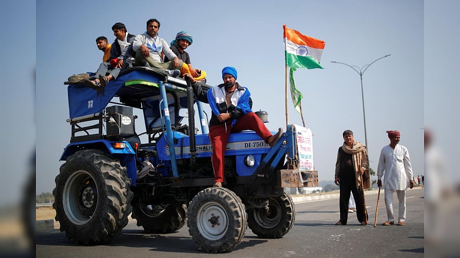 Farmers stand atop a tractor as they take part in a three-hour "chakka jam," or road blockade, as part of protests against farm laws on a highway on the outskirts of New Delhi, India, February 6, 2021. Credit: Reuters Photo