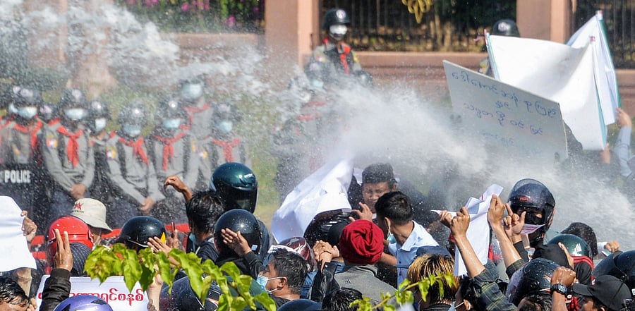 Myanmar police (in background) fire water cannon at protesters as they continue to demonstrate against the February 1 military coup in the capital Naypyidaw. Credit: AFP Photo