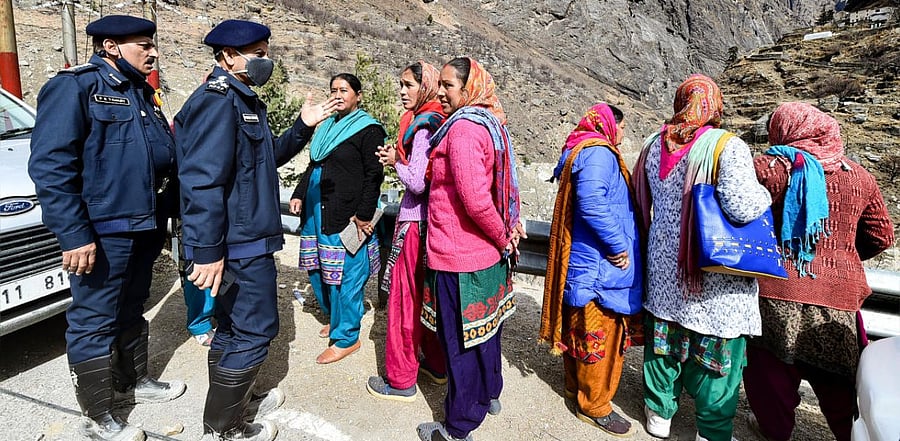 Rescue workers interact with local women near flash flood hit Raini village following a glacier burst, in Chamoli district of Uttarakhand, Tuesday, Feb. 9, 2021. Credit: PTI Photo.