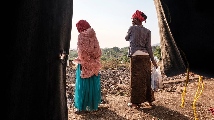 Internally Displaced People (IDP), fleeing from violence in the Metekel zone in Western Ethiopia, stand outside a tent at a camp in Chagni, Ethiopia. Credit: AFP Photo.