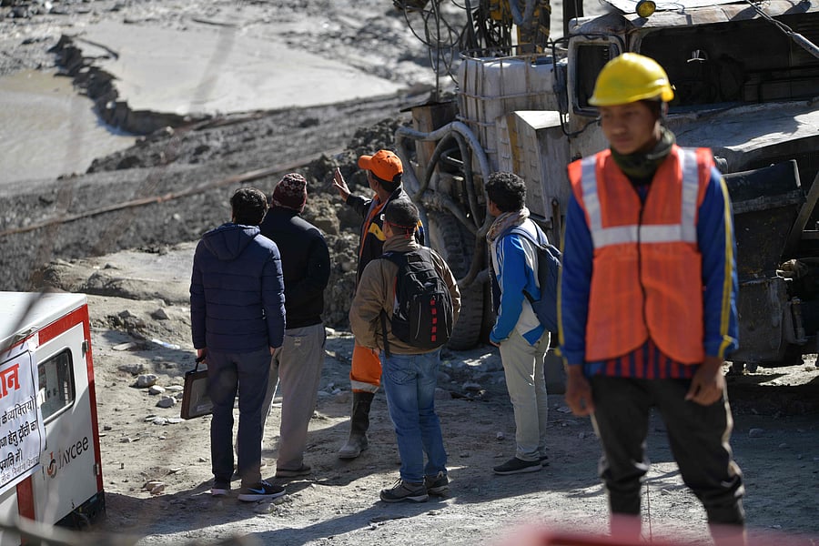 Defence research and development organisation (DRDO) scientists talk with an emergency and rescue official after arriving near Tapovan tunnel, where dozens are still feared to be trapped, during rescue operations in Tapovan of Chamoli district on February 12, 2021 following a flash flood thought to have been caused when a glacier burst on February 7. Credit: AFP Photo