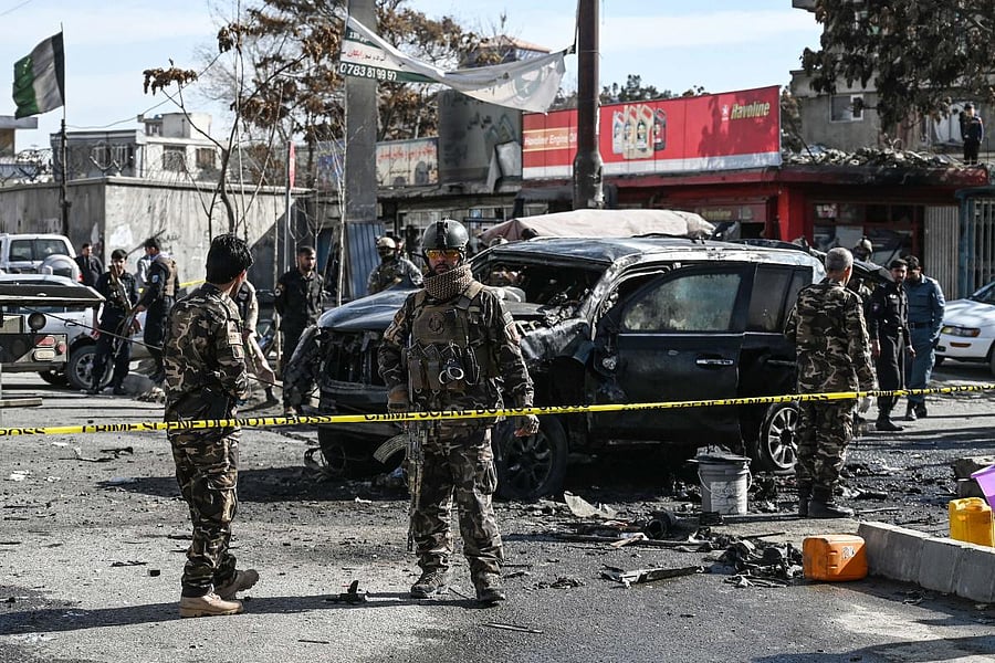 Security personnel investigate a damaged armoured car at the site after multiple bomb blasts, killing at least two people, in Kabul. Credit: AFP photo.