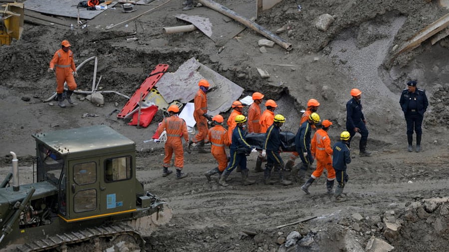 Members of National Disaster Response Force (NDRF) and State Disaster Response Fund (SDRF) carry the body of a victim after recovering it from the debris inside a tunnel during a rescue operation after a flash flood swept a mountain valley destroying dams and bridges, in Tapovan in the northern state of Uttarakhand, India, February 14, 2021. Credit: Reuters Photo