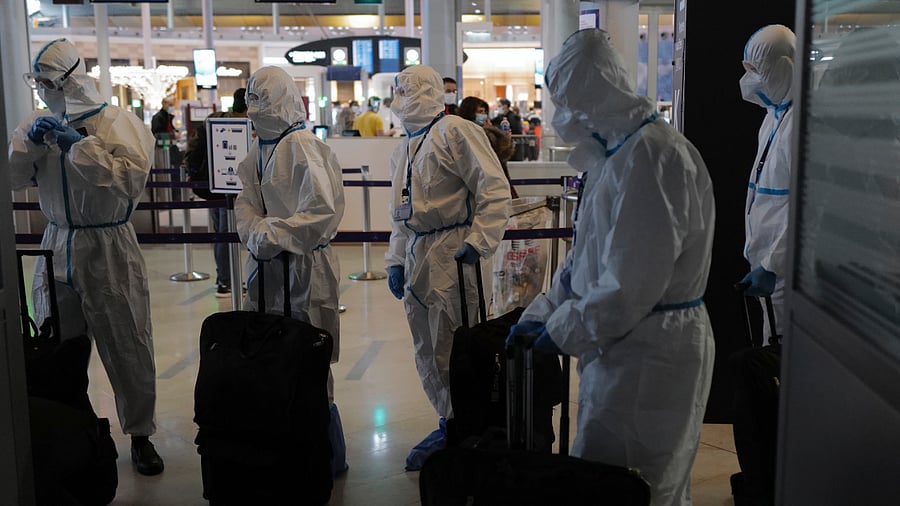Passengers from Asia wearing protective gear arrive to board their plane. Credit: AP Photo
