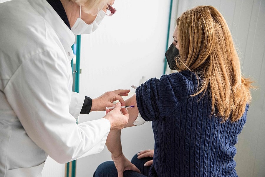 A medical worker (R) receives a dose of the Pfizer-BioNTech vaccine against the Covid-19. Credit: AFP Photo