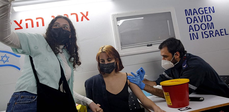 A health worker administers the COVID-19 vaccine to an Israeli at mobile clinic parked near a bar in the coastal city of Tel Aviv. Credit: AFP Photo