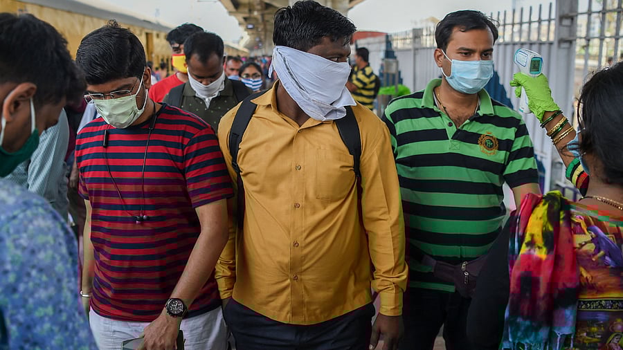 Passengers stand in a queue for a Covid-19 medical screening. Credit: AFP Photo