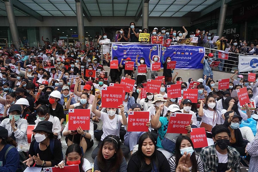 Protesters hold signs during a demonstration against the military coup in Yangon. Credit: AFP photo. 