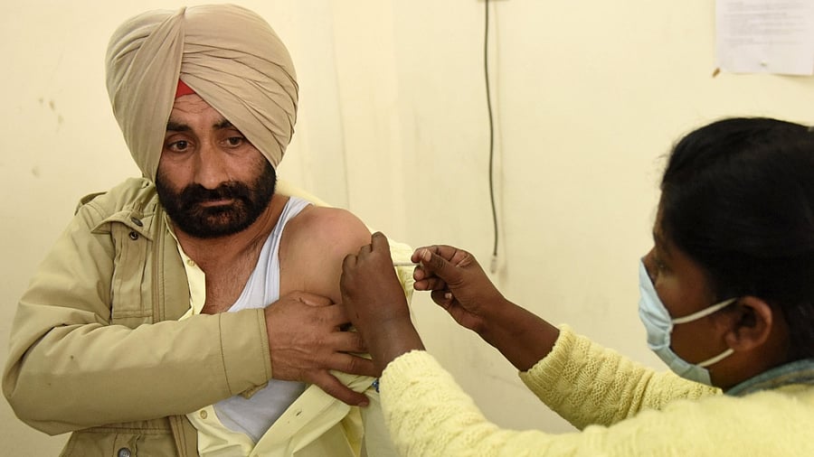 A medical staff inoculates a police personnel with a Covid-19 coronavirus vaccine at the Civil hospital in Amritsar on February 9, 2021. Credit: AFP Photo