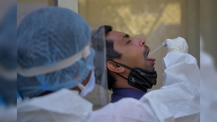 A health worker collects a swab sample from a man to test for the Covid-19 coronavirus at the KC General Hospital in Bengaluru on February 1, 2021. Credit: AFP Photo