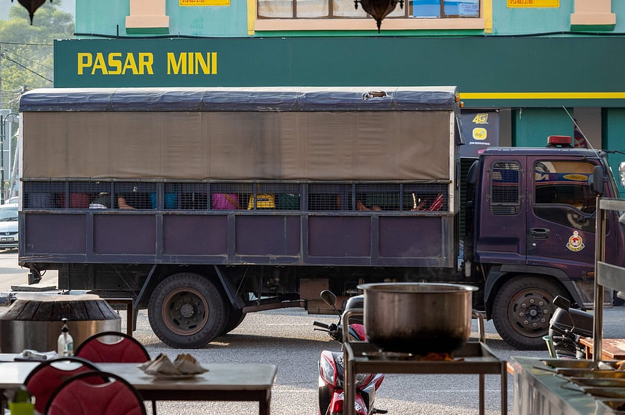 An immigration truck carrying Myanmar migrants from Malaysia back to their homeland, is seen heading towards the Naval base in Lumut, outside Kuala Lumpur. Credit: AFP Photo