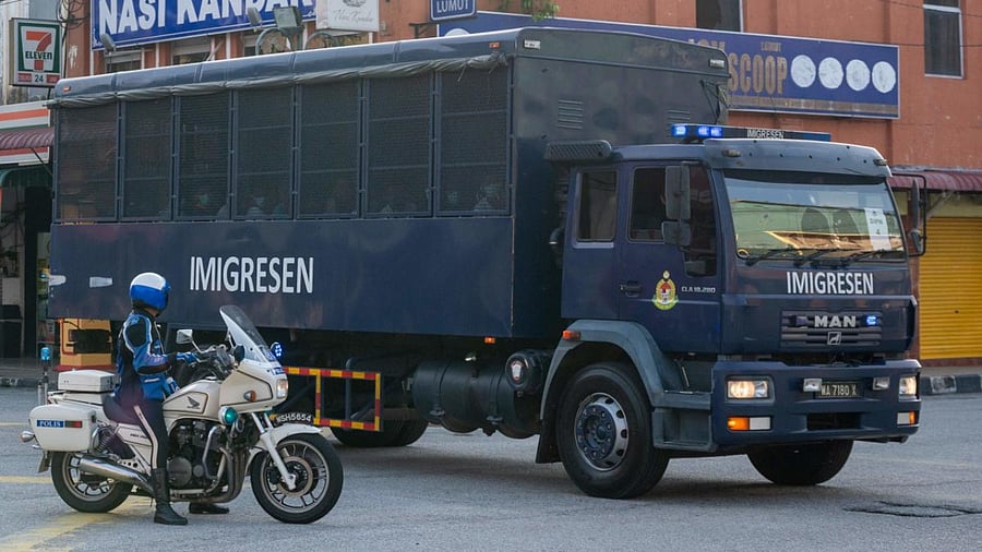 An immigration truck carrying Myanmar migrants from Malaysia back to their homeland, is seen heading towards the Naval base in Lumut, outside Kuala Lumpur. Credit: AFP.