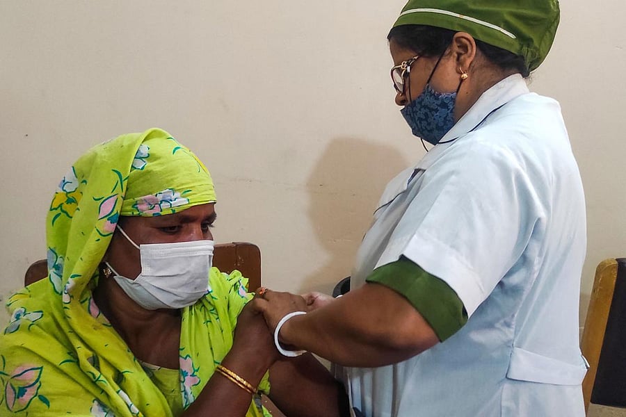A sex worker (L) from the country's largest brothel receives a dose of a Covid-19 vaccine in Daulatdia on February 25, 2021. Credit: AFP photo. 