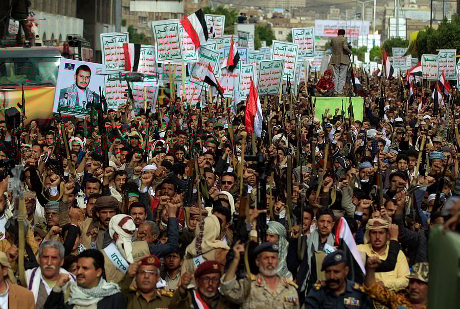 Supporters of the Yemeni Huthi rebels raise placards during protest against blockade imposed on their country by the Saudi coalition,in the capital Sanaa, on February 26, 2021. The writing on the placards reads in Arabic: "God is gear, death to America and Israel, curse on the Jews, victory to Islam'. - Iran has backed the Huthi rebels during the six-year-old war against Yemen's internationally recognised government, supported since 2015 by a military coalition led by Tehran-rival Saudi Arabia. Credit: AFP Photo