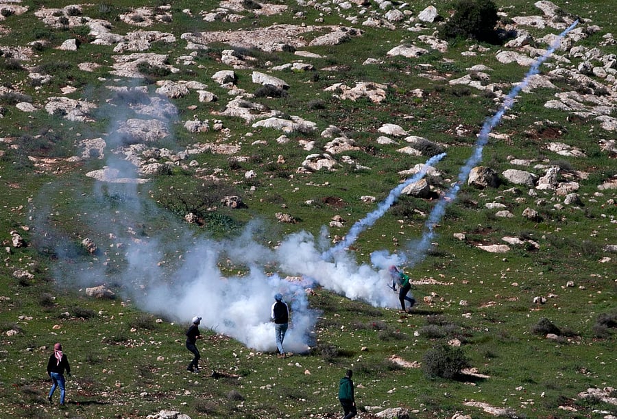 Children from the village of Beit Dajan, east of Nablus, hurl rocks at Israeli soldiers during a protest against the establishment of a settlement outpost on the lands of the village, on February 26, 2021. Credit: AFP Photo