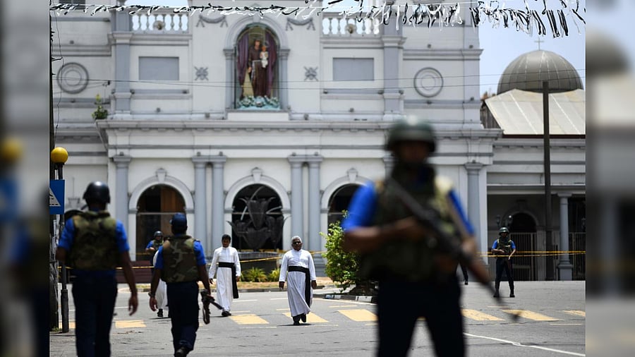 Priests walk on a blocked street as soldiers stand guard outside St. Anthony's Shrine in Colombo on April 25, 2019, following a series of bomb blasts targeting churches and luxury hotels on the Easter Sunday in Sri Lanka. Credit: AFP Photo