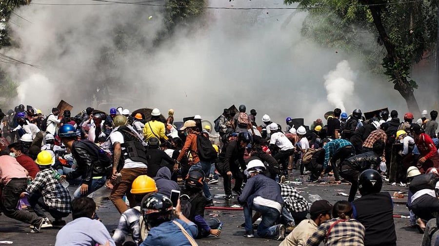 Protesters react after police fired tear gas during a demonstration against the military coup in Mandalay. Credit: AFP.