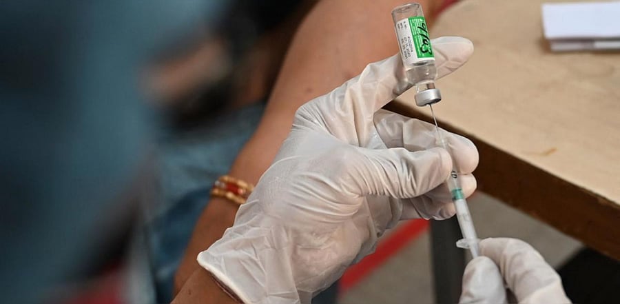 A health worker prepares to vaccinate a senior citizens with the coronavirus vaccine at a government hospital in Faridabad. Credit: AFP photo.