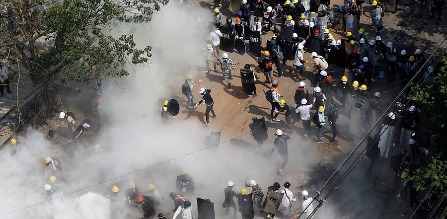 Protesters react as they engulfed by tear gas fired by police. Credit: AFP Photo