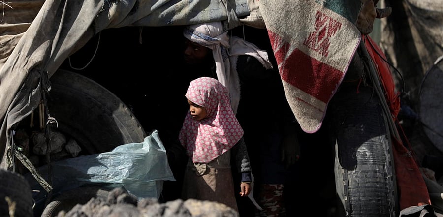 A girl stands outside her family's hut at a camp for internally displaced people on the outskirts of Sanaa, Yemen. Credit: Reuters photo.